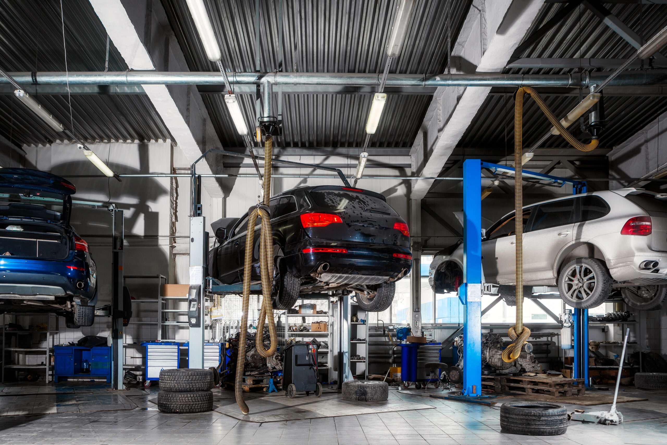 Cars on lifts in a repair shop.